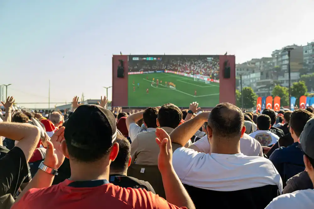 Fans reacting to an exciting play on the big screen