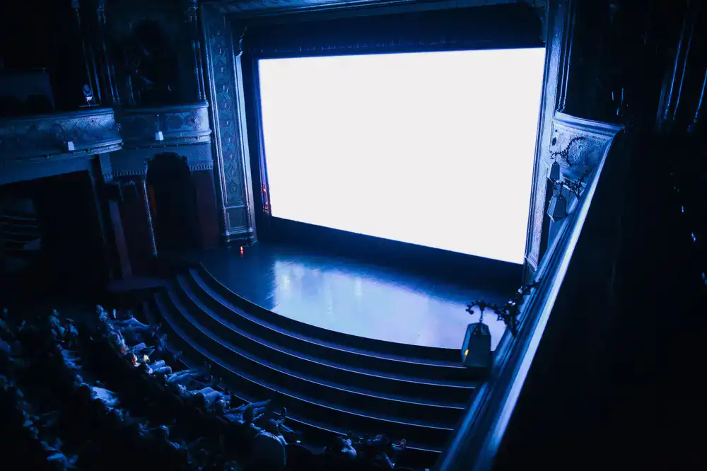 Full venue crowd cheering at big screens