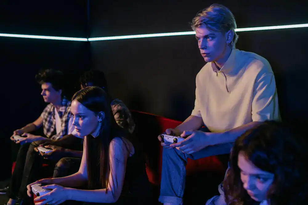 Group of friends playing together in a neon lit gaming lounge