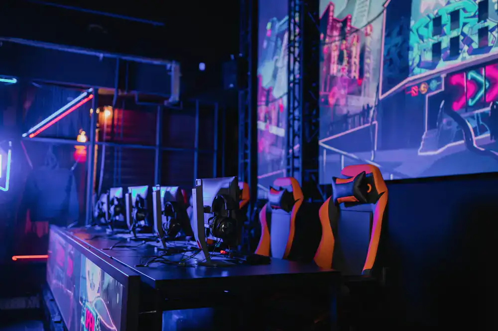 Row of high-end gaming PCs in a dimly lit room with neon accents
